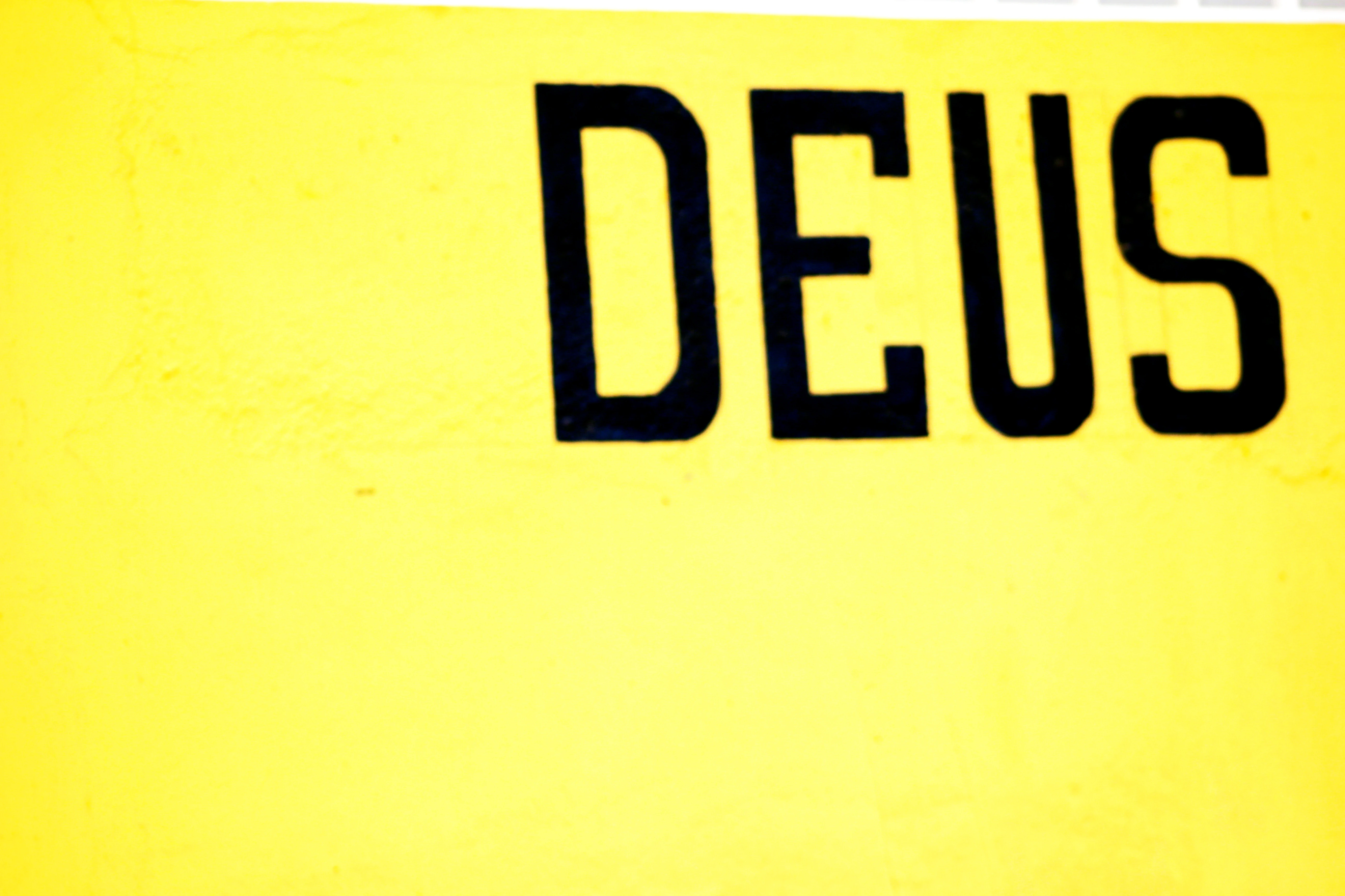 DEUS painted in bold black letters on yellow wall