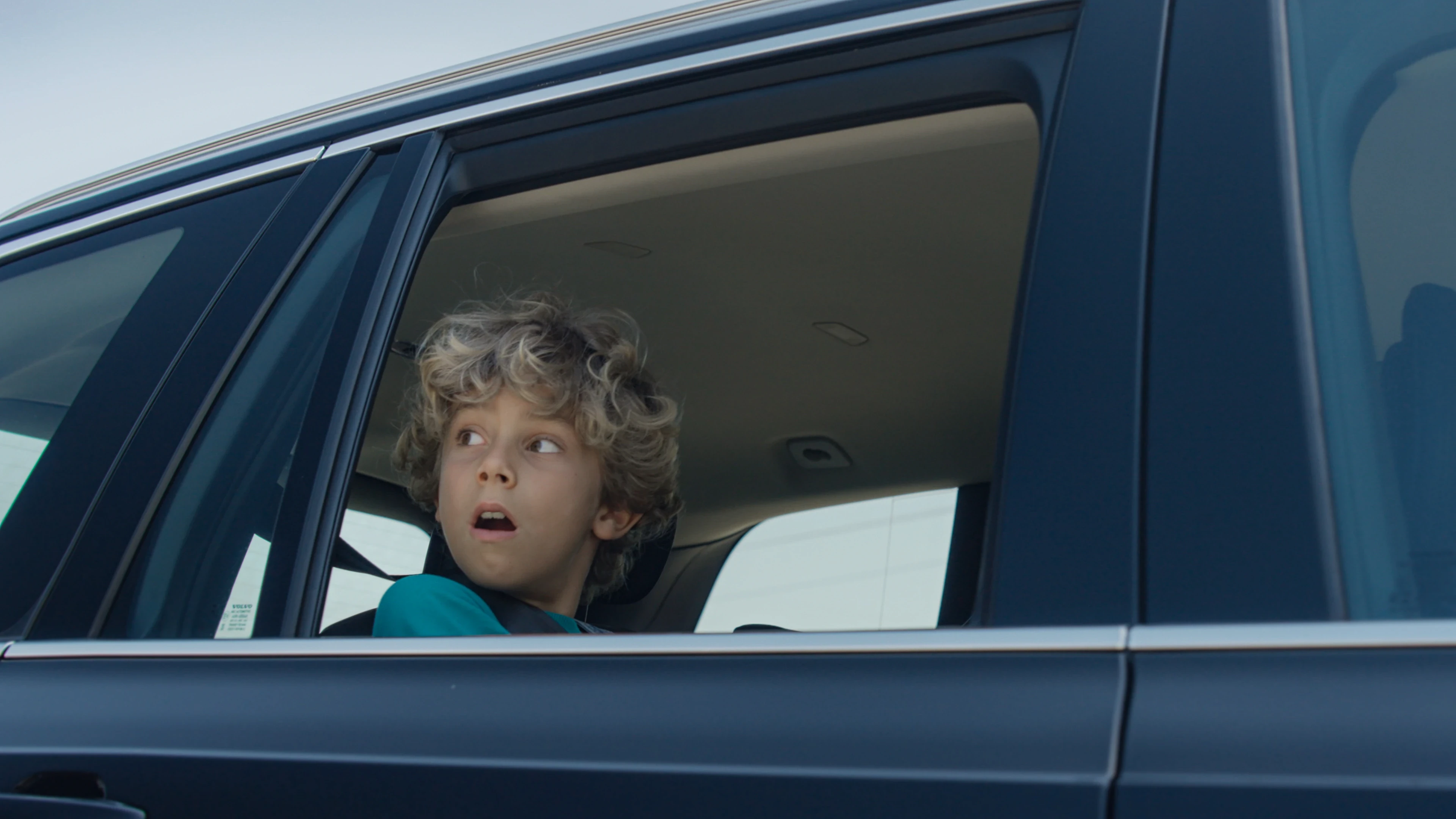 Child looking up in wonder through car window