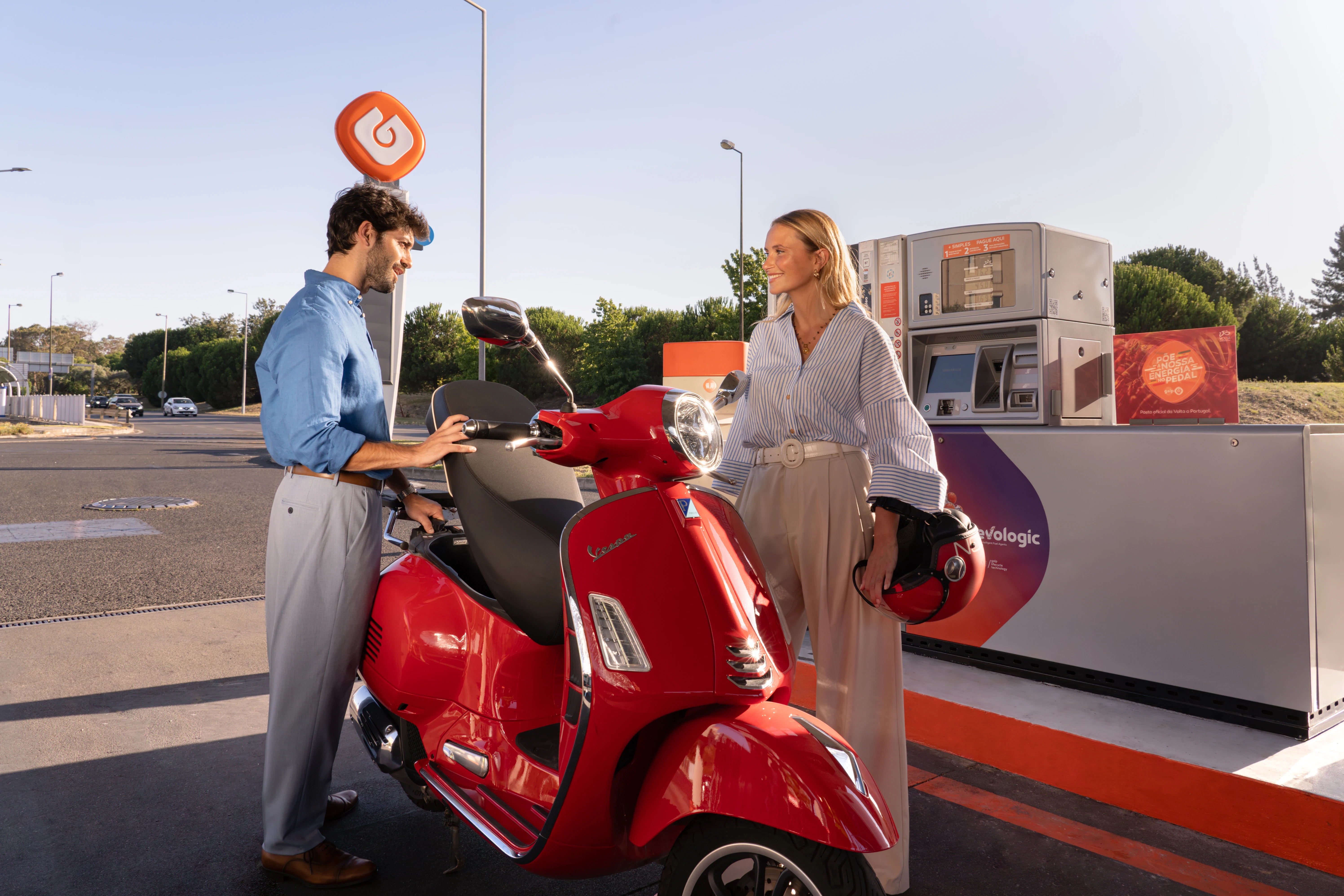 Couple with red Vespa at GALP station: real people, real moments