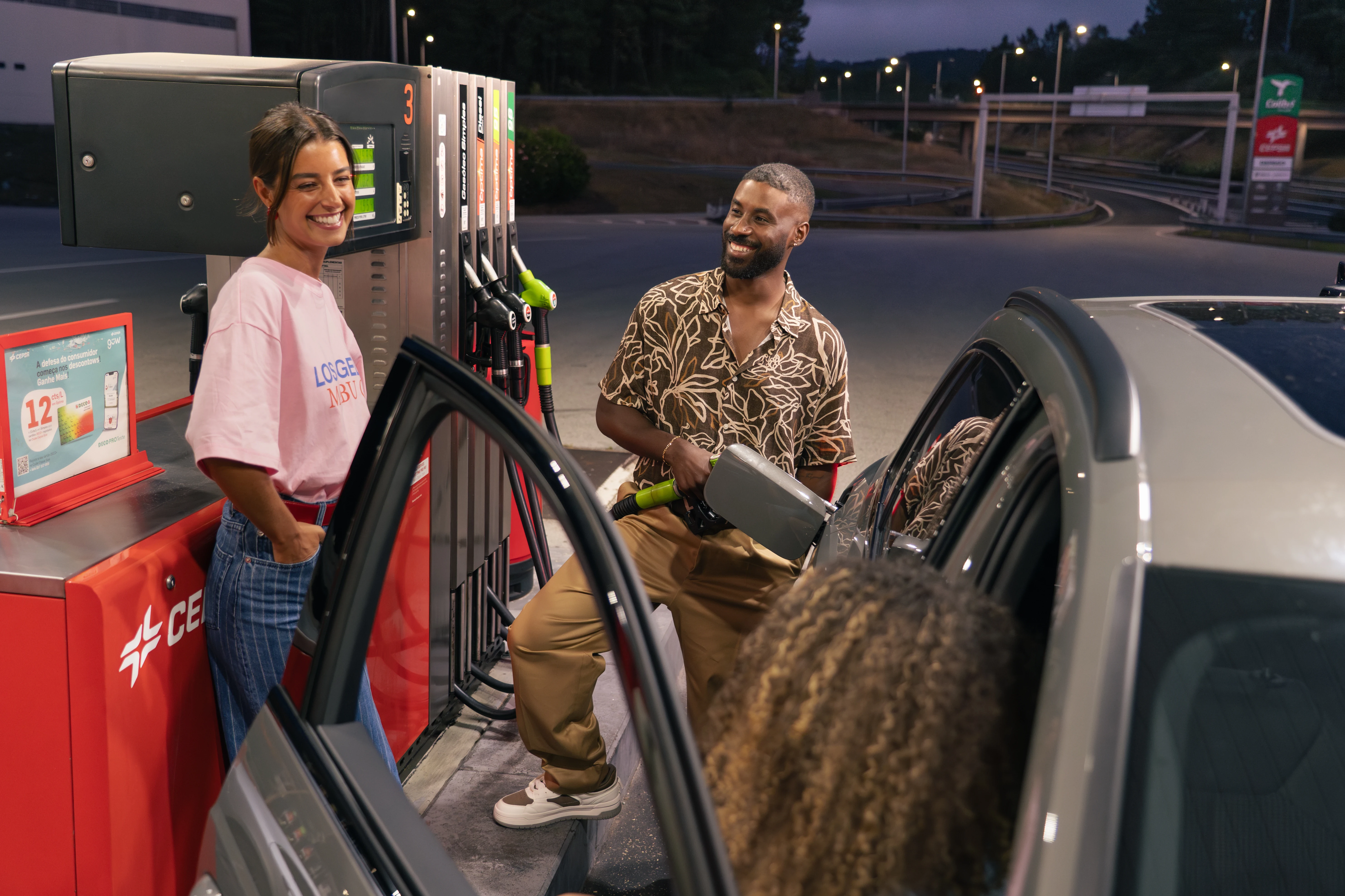 Friends fuelling at CEPSA station at night: candid lifestyle moment